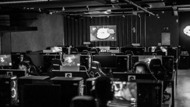 Black and white view of an active esports gaming studio with players immersed in video games.