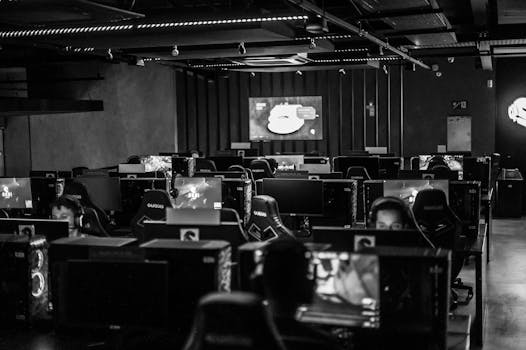 Black and white view of an active esports gaming studio with players immersed in video games.